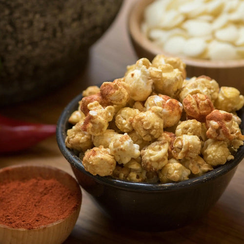 Spicy seasoned popcorn in a black bowl.