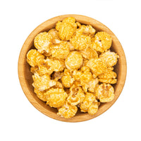 Wooden bowl filled with popcorn on a white background