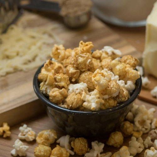 A bowl of caramel and regular popcorn.