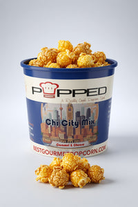 A container of Popped Chi City Mix Sauté & Cheese popcorn, filled with golden-brown popcorn and with a small pile in front, on a light gray background.