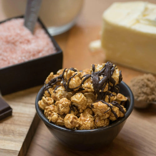 A bowl of caramel popcorn drizzled with dark chocolate.