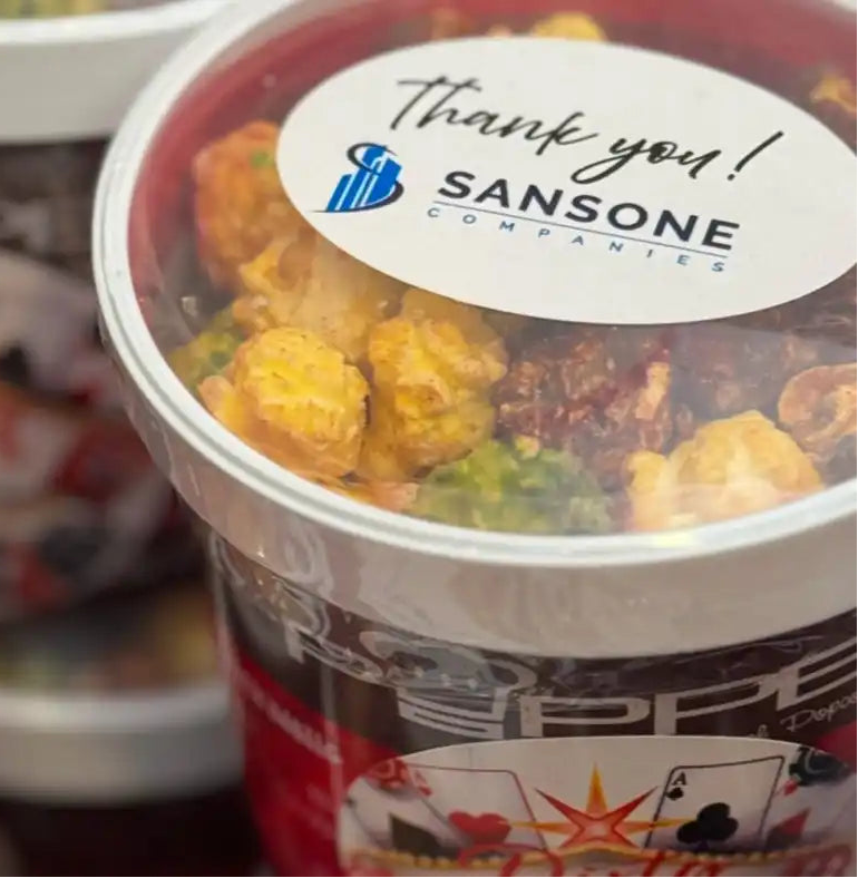 Containers of food with visible branding and labels on a reflective surface