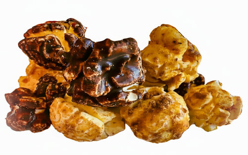 A pile of crunch nato chocolate and biscoff cookies gourmet popcorn coated in caramel and dark chocolate glaze
