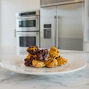 Plate of gourmet popcorn on a marble countertop with kitchen appliances in the background