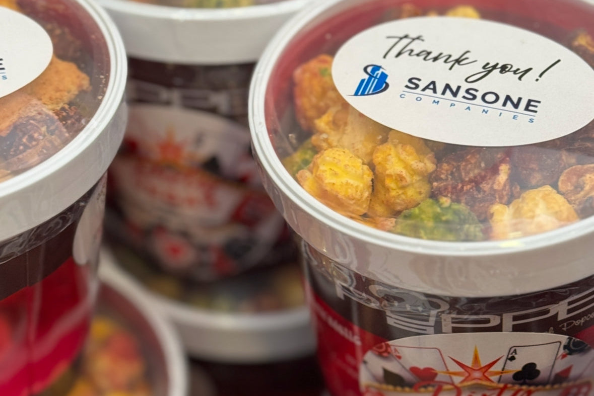 Containers of food with visible branding and labels on a reflective surface