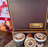 Chocolate popcorn tin box with gold accents and ’love pops’ branding.