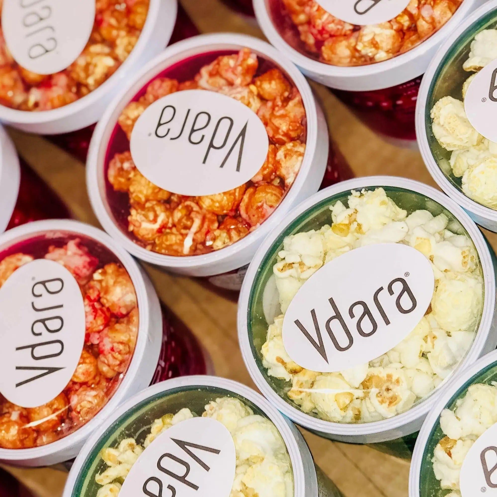 Individual servings of flavored popcorn in clear, lidded containers.