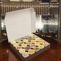 Box of assorted snacks in front of a fountain show at night.