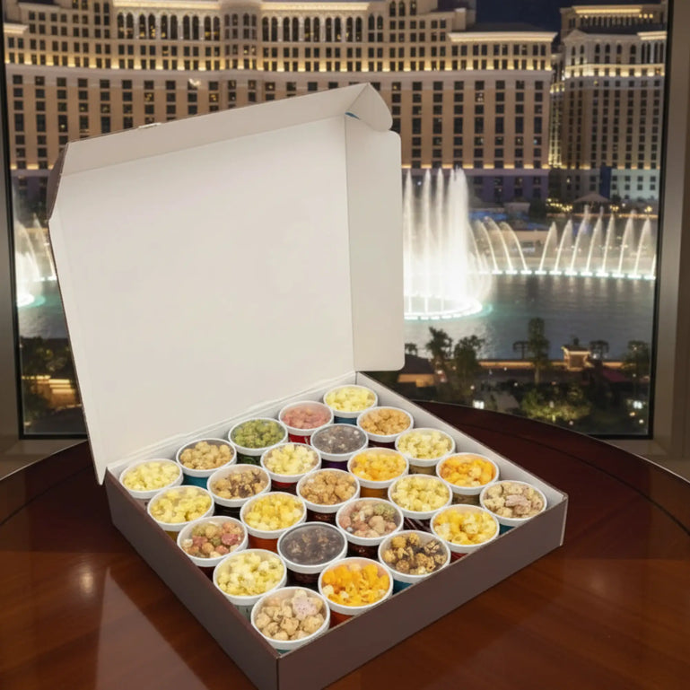 Box of assorted snacks in front of a fountain show at night.