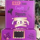 Two stacked purple Halloween-themed boxes with mummy and ghost illustrations.