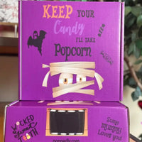 Two stacked purple Halloween-themed boxes with mummy and ghost illustrations.