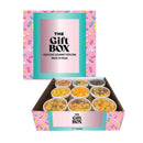 An open gift box containing nine small containers of gourmet popcorn.