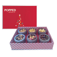 Red and white striped popcorn tin box with colorful contents.