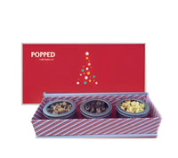 Red and white striped popcorn tin box with three compartments containing assorted flavored popped corn.