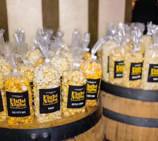 Popcorn bag with clear plastic, black label and yellow popcorn inside.
