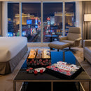 Luxury hotel room with cityscape view, and popped las vegas popcorn gift basket on the table items.