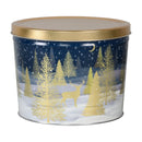 A festive navy blue metal tin with a gold lid, featuring an illustrated winter scene of golden pine trees and a deer under a starry night sky.
