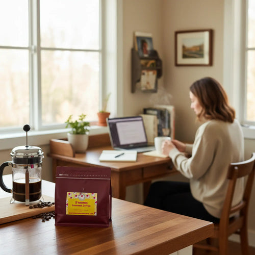 Maroon bag of popped gourmet smores flavored coffee with ground coffee beans and a yellow floral label